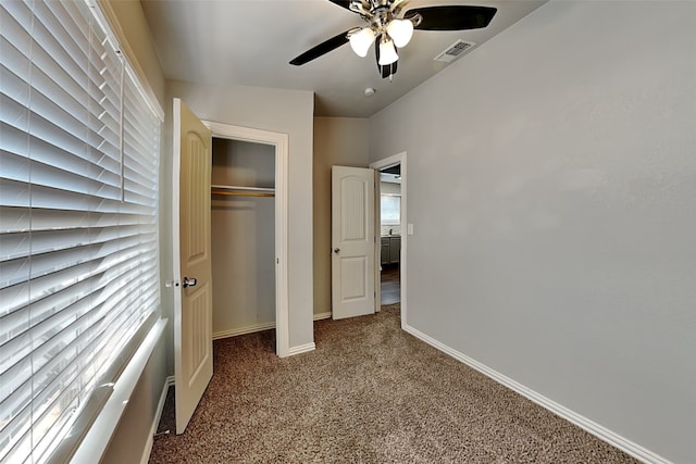 unfurnished bedroom with ceiling fan, carpet floors, and a closet