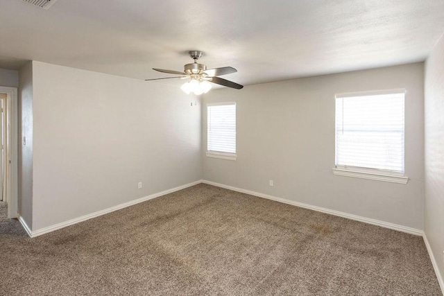carpeted empty room with a ceiling fan and baseboards