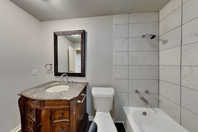 full bathroom featuring vanity, a textured ceiling, tiled shower / bath combo, and toilet