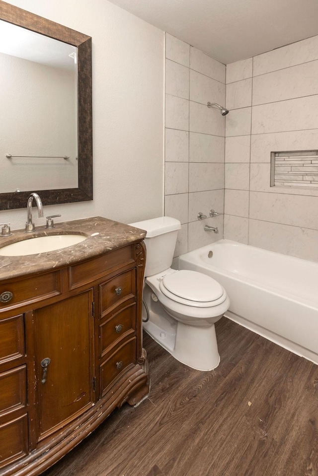 full bathroom with wood finished floors, toilet, vanity, and tub / shower combination