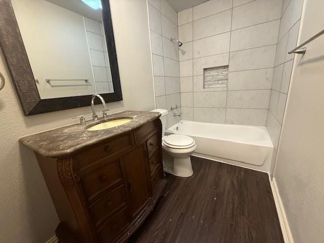 full bathroom with vanity, hardwood / wood-style flooring, toilet, and tiled shower / bath combo