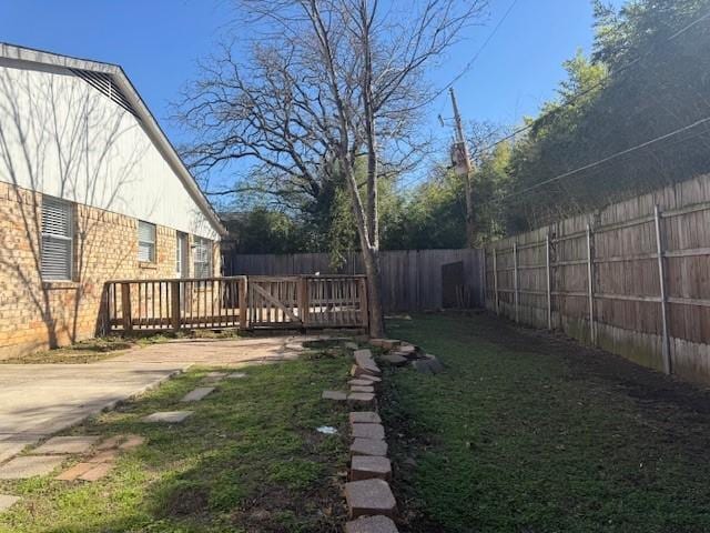fenced backyard featuring a deck