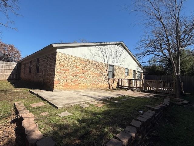 back of property featuring a deck and a patio