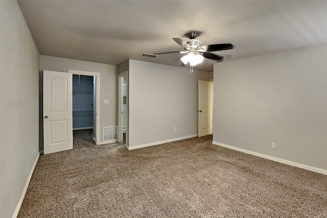 unfurnished bedroom featuring ceiling fan, a walk in closet, carpet floors, and a closet