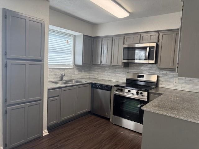 kitchen featuring appliances with stainless steel finishes, dark hardwood / wood-style floors, sink, and gray cabinetry