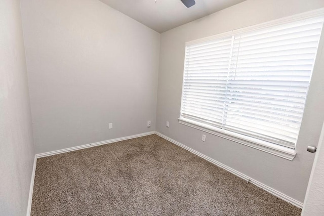 carpeted spare room featuring ceiling fan and baseboards