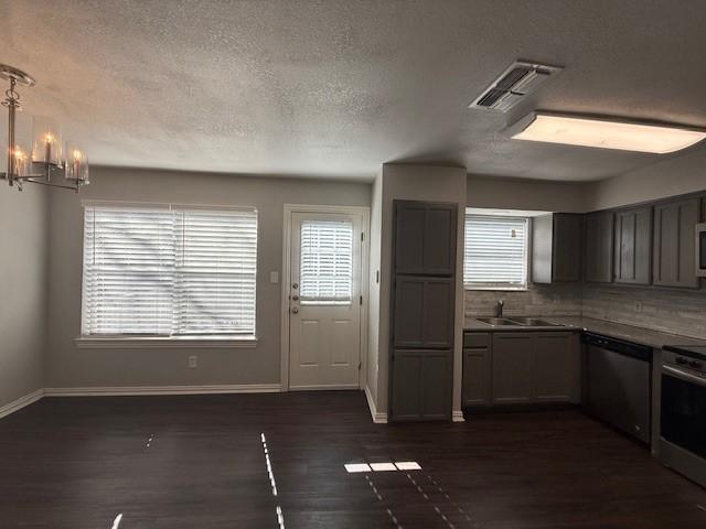 kitchen featuring pendant lighting, sink, dishwasher, stove, and dark hardwood / wood-style flooring