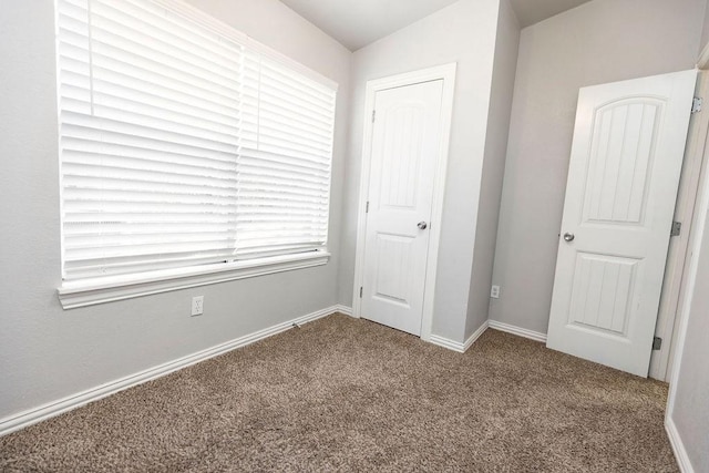 unfurnished bedroom featuring carpet and baseboards