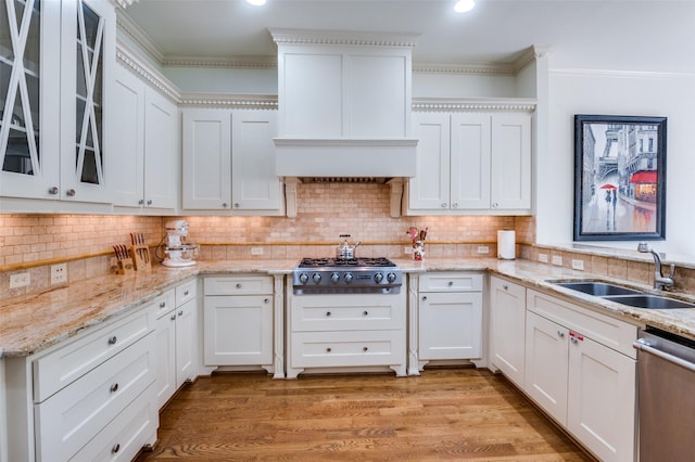 kitchen with white cabinetry, appliances with stainless steel finishes, sink, and light hardwood / wood-style flooring