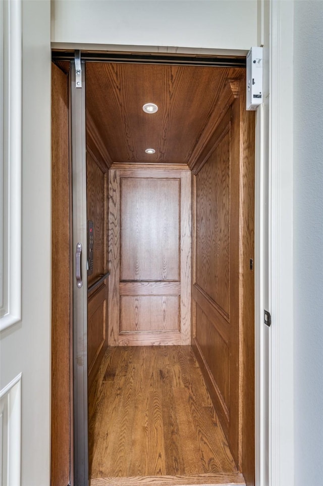 interior space with elevator, wood-type flooring, and wooden ceiling