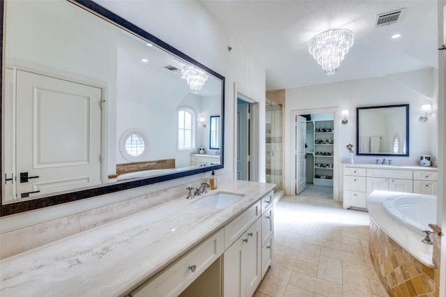 bathroom featuring independent shower and bath, vanity, and a chandelier