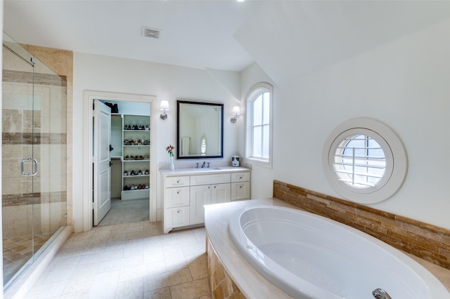 bathroom featuring vanity and independent shower and bath