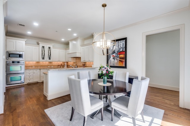 dining room featuring crown molding, dark hardwood / wood-style floors, and a chandelier