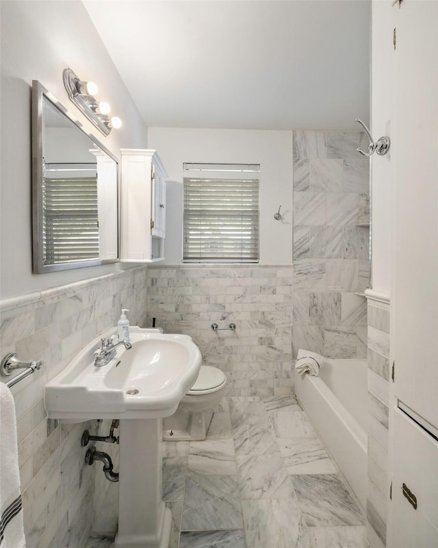 bathroom featuring tile walls, bathtub / shower combination, and toilet