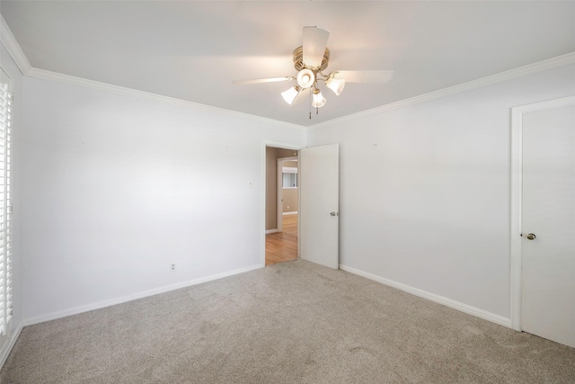 empty room with ceiling fan, light colored carpet, and ornamental molding