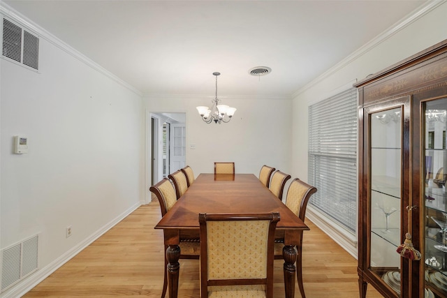 dining room with a notable chandelier, crown molding, and light hardwood / wood-style flooring