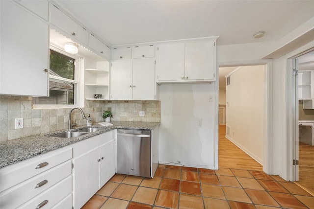 kitchen with white cabinetry, dishwasher, sink, light tile patterned floors, and light stone countertops