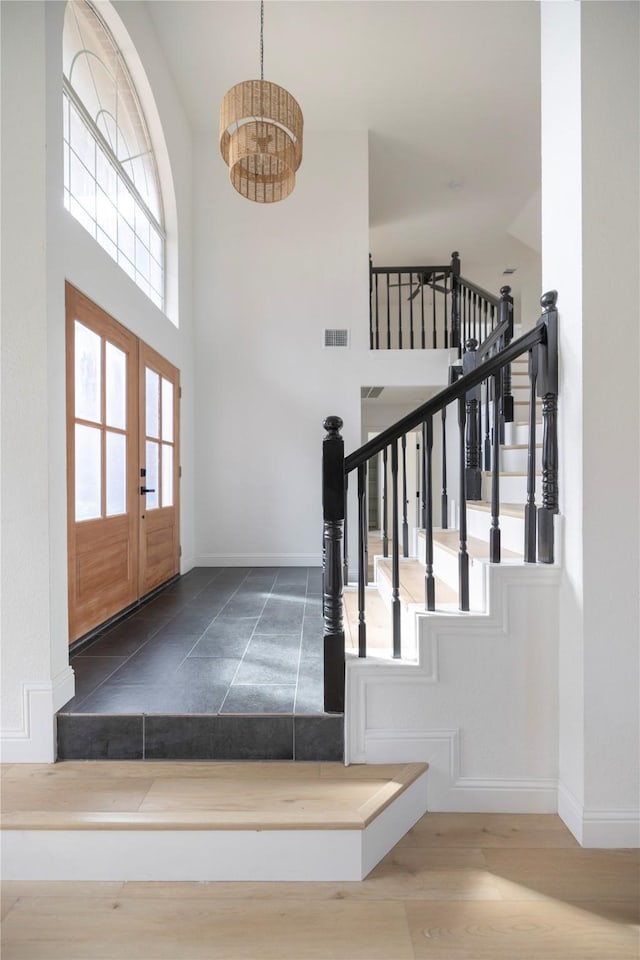 foyer featuring a notable chandelier, a wealth of natural light, french doors, and wood-type flooring