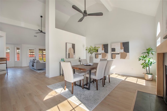 dining room featuring beamed ceiling, ceiling fan, high vaulted ceiling, and light wood-type flooring