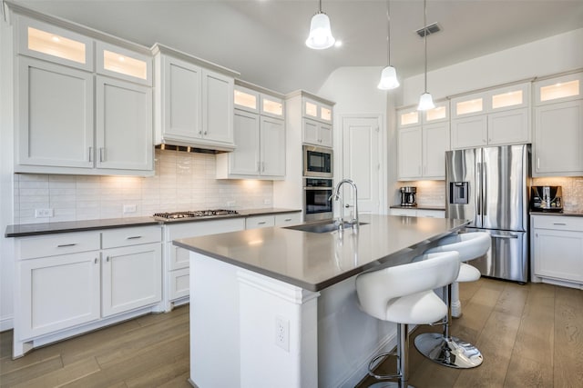 kitchen with decorative light fixtures, white cabinetry, sink, a kitchen island with sink, and stainless steel appliances