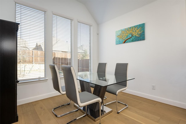 dining space featuring hardwood / wood-style flooring and lofted ceiling