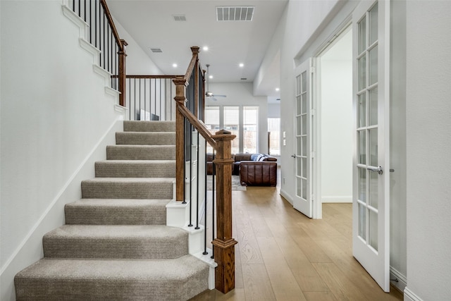 staircase featuring hardwood / wood-style floors and french doors