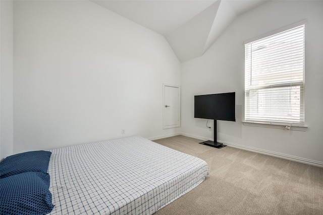 bedroom featuring light colored carpet and vaulted ceiling