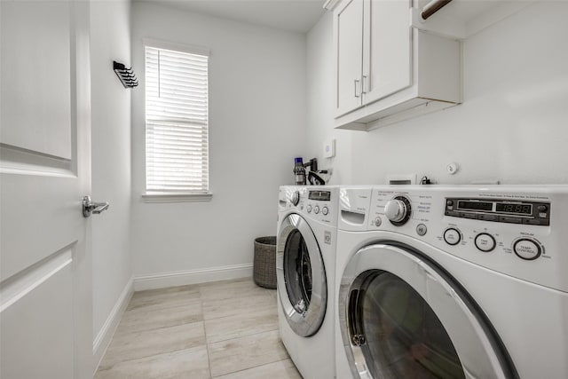 clothes washing area with separate washer and dryer, light tile patterned floors, plenty of natural light, and cabinets