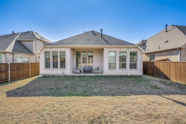 rear view of property with a yard and a patio