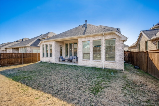 rear view of property with a yard and a patio area