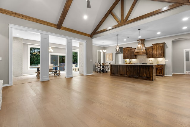 unfurnished living room with an inviting chandelier, light hardwood / wood-style floors, high vaulted ceiling, and beamed ceiling