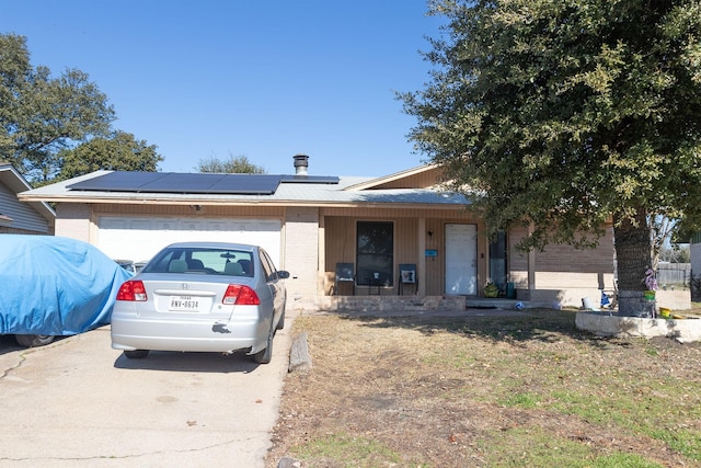 view of front facade with a garage, covered porch, and solar panels