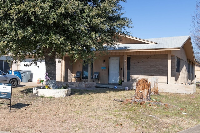 view of front of house with a porch, a garage, and a front lawn