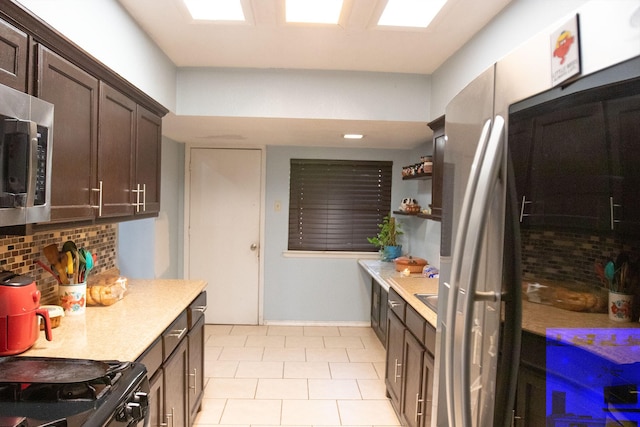 kitchen featuring dark brown cabinetry, appliances with stainless steel finishes, and decorative backsplash