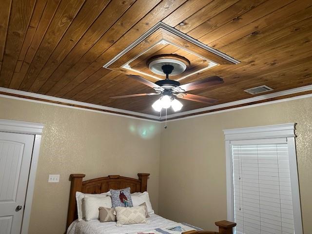 bedroom featuring ceiling fan, ornamental molding, and wooden ceiling