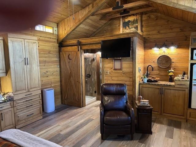 living area with hardwood / wood-style floors, wood ceiling, wooden walls, and a barn door