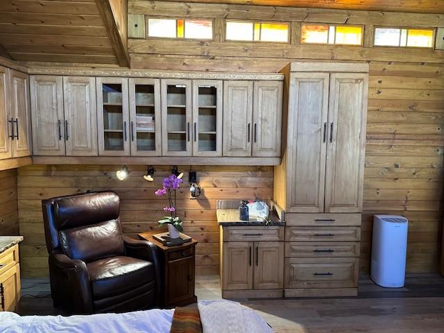 bar featuring wooden walls, wooden ceiling, beamed ceiling, and light brown cabinets