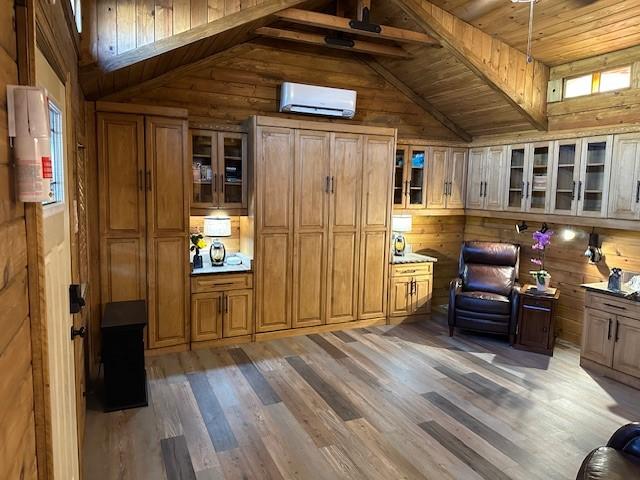 interior space with dark hardwood / wood-style flooring, a wall mounted air conditioner, wooden walls, and lofted ceiling