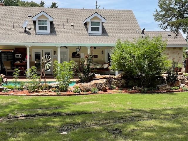 rear view of property featuring a lawn