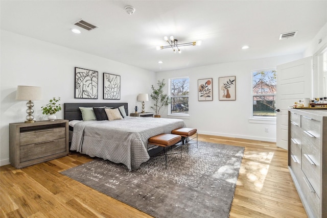 bedroom with an inviting chandelier and light hardwood / wood-style floors