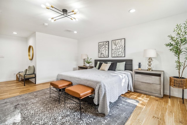 bedroom featuring an inviting chandelier and hardwood / wood-style floors