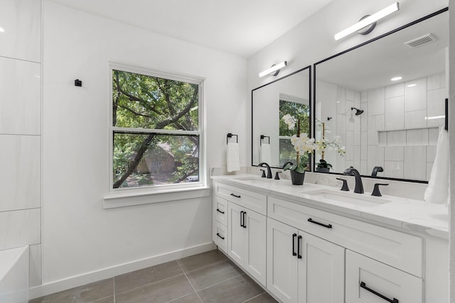 full bathroom featuring tile patterned flooring, visible vents, a tile shower, and a sink