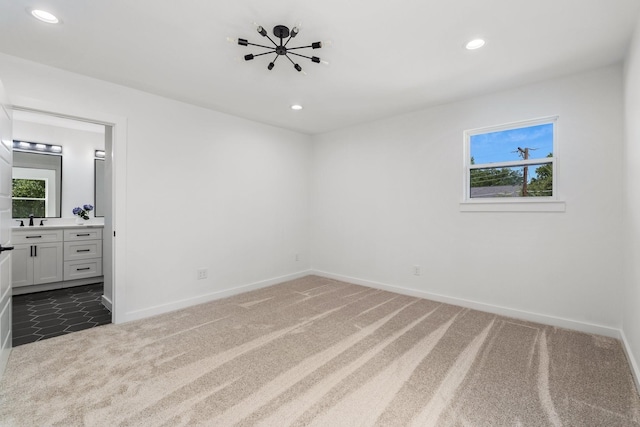 interior space with connected bathroom, dark carpet, and sink