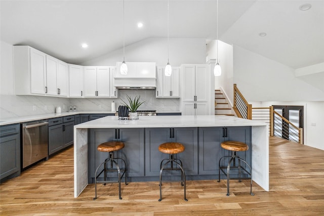 kitchen with a kitchen island, dishwasher, a breakfast bar area, gray cabinetry, and hanging light fixtures