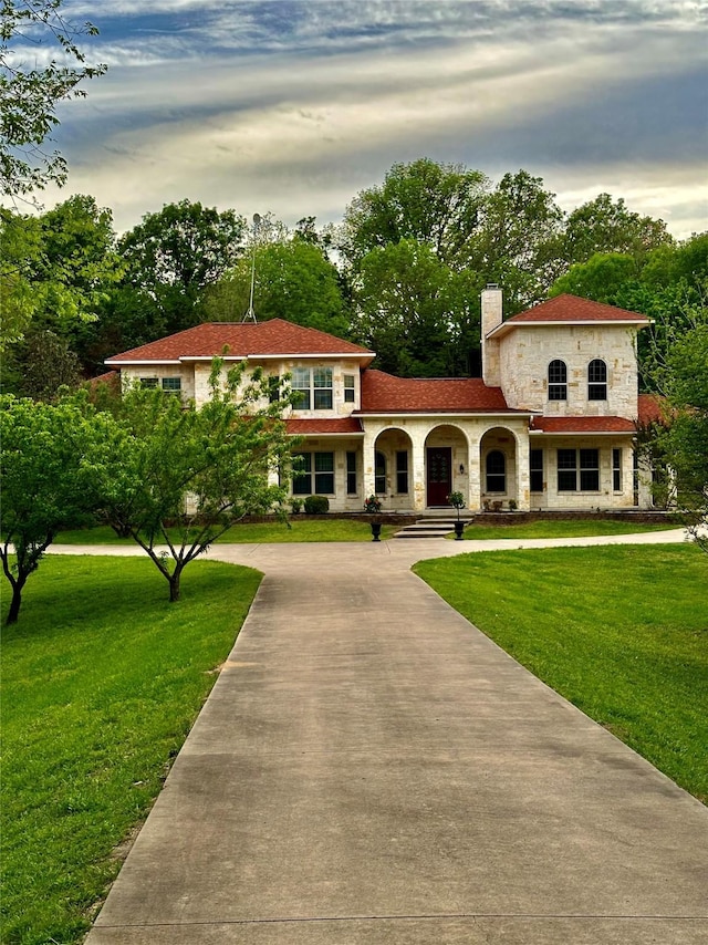 mediterranean / spanish home featuring a yard