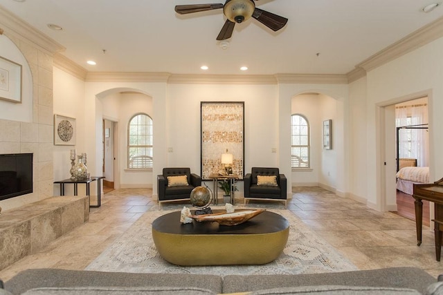 living room featuring a fireplace, ornamental molding, and ceiling fan