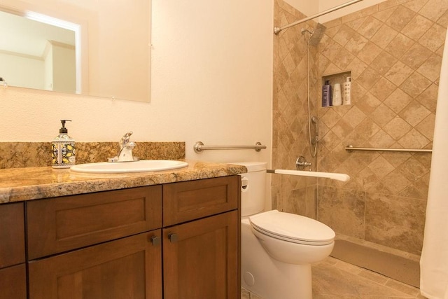 bathroom featuring vanity, toilet, and tiled shower