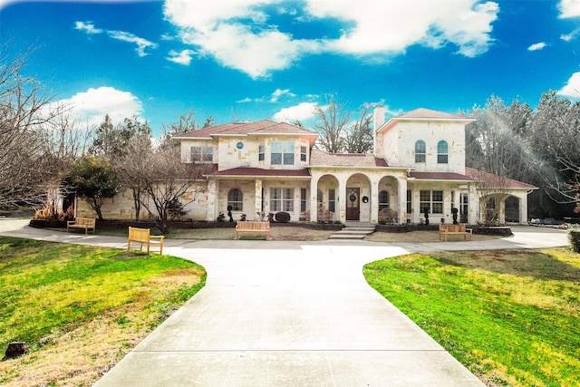 mediterranean / spanish house featuring covered porch and a front lawn