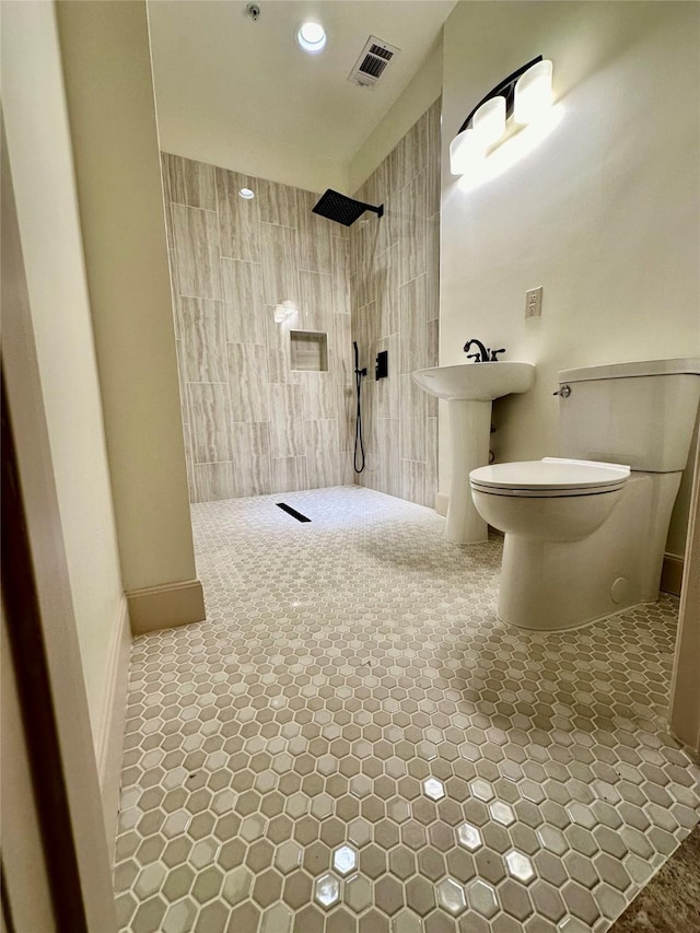 bathroom featuring tiled shower and toilet