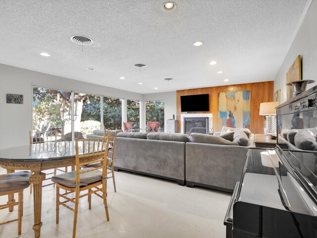 living room featuring a textured ceiling and wood walls